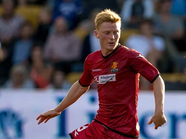 Anders Christiansen i FC Nordsjællands röda matchtröja med bollen vid fötterna